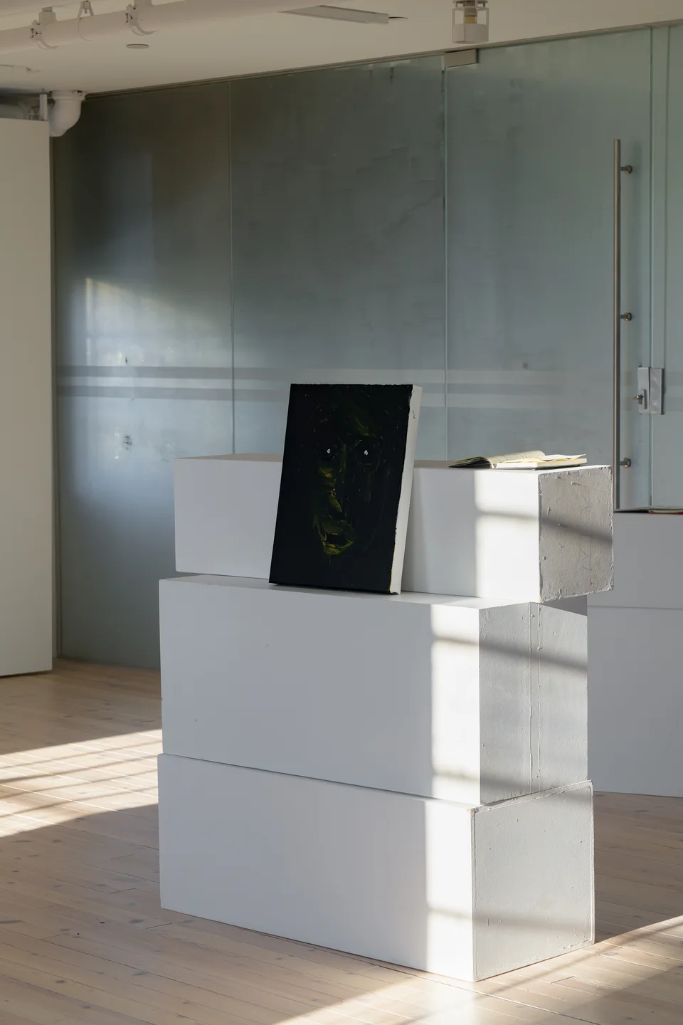 Portrait and notebook on stacked display plinths